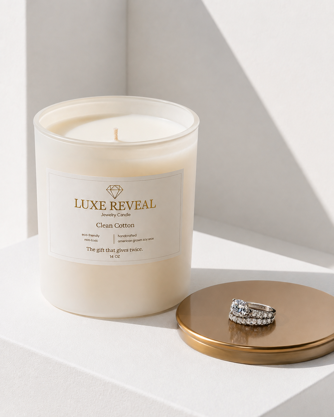 Open Clean Cotton Luxe Reveal candle with the revealed diamond ring displayed on the champagne lid