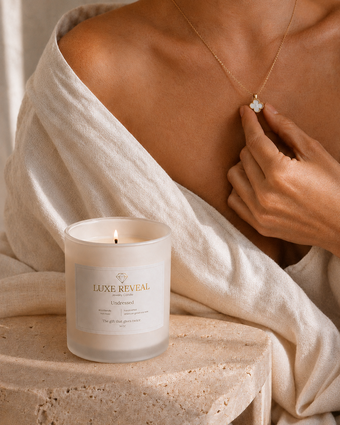 Model wearing the revealed Luxe Reveal necklace beside the lit Undressed candle